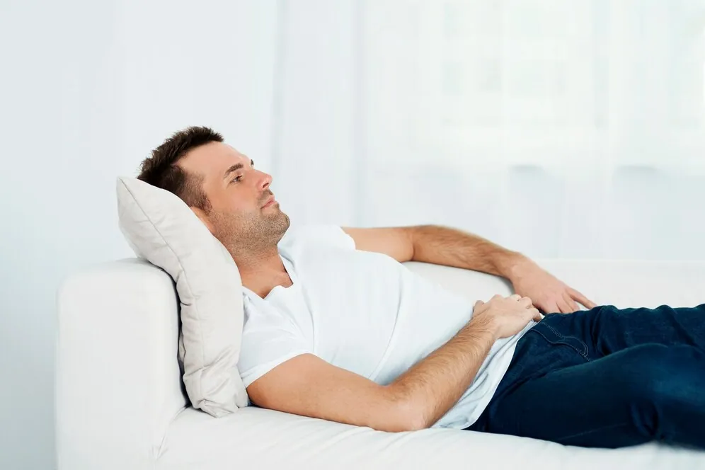 Man relaxing on a sofa with poor posture