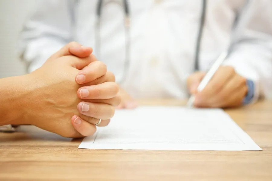 Doctor writing a report of findings with a patient